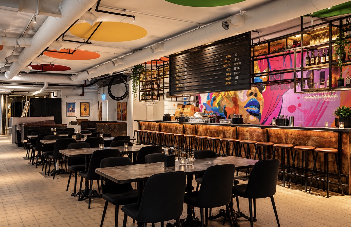 Restaurang och bar med muralmålning, blottade installationer och färgade takskivor